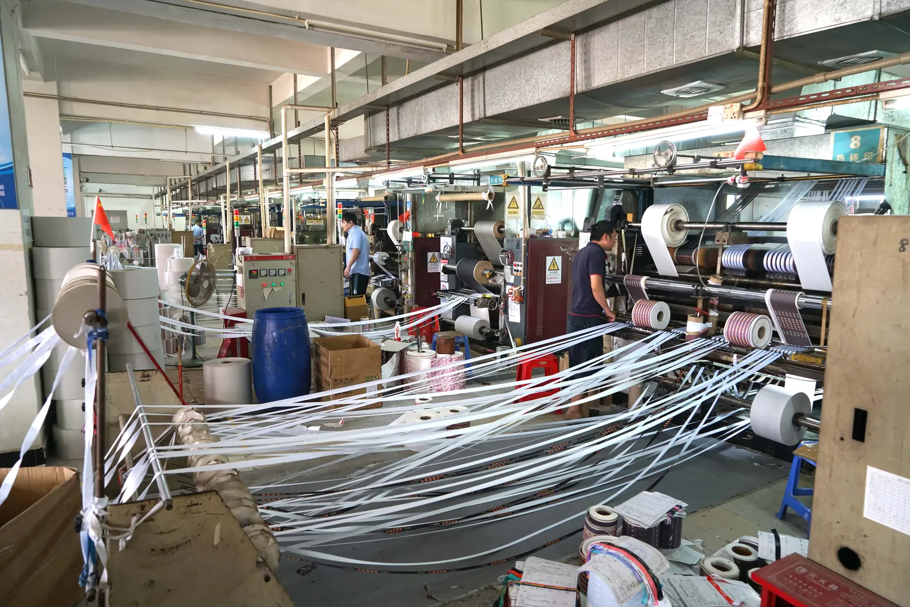 Actual LANYVO workshop photograph of heat-transfer equipment with printed webbing